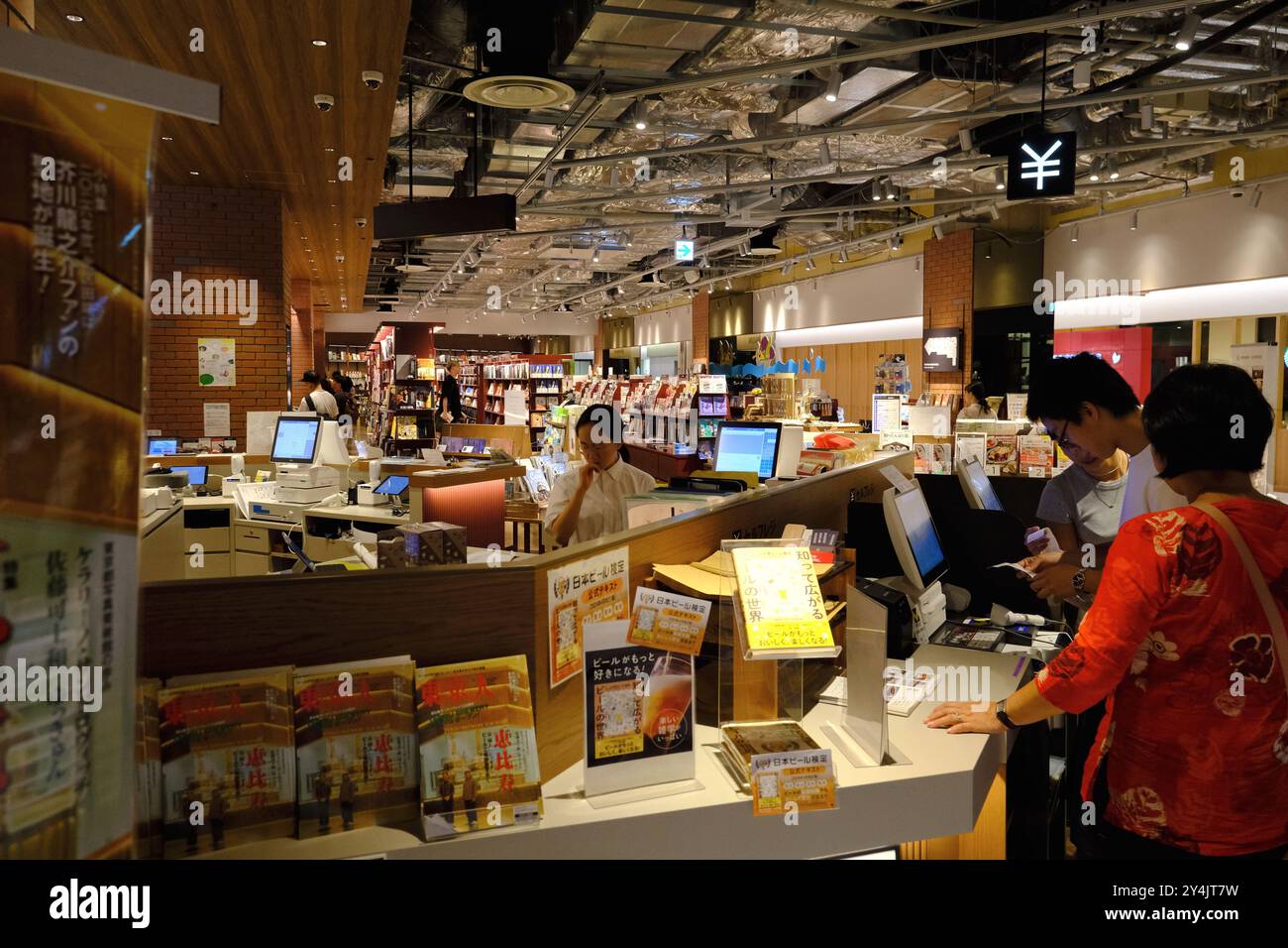Customers buying books at self-checkout counter in Tsutaya Bookstore in Yebisu Garden Place Center Plaza, Ebisu,Shibuya Ward,Tokyo,Japan Stock Photo