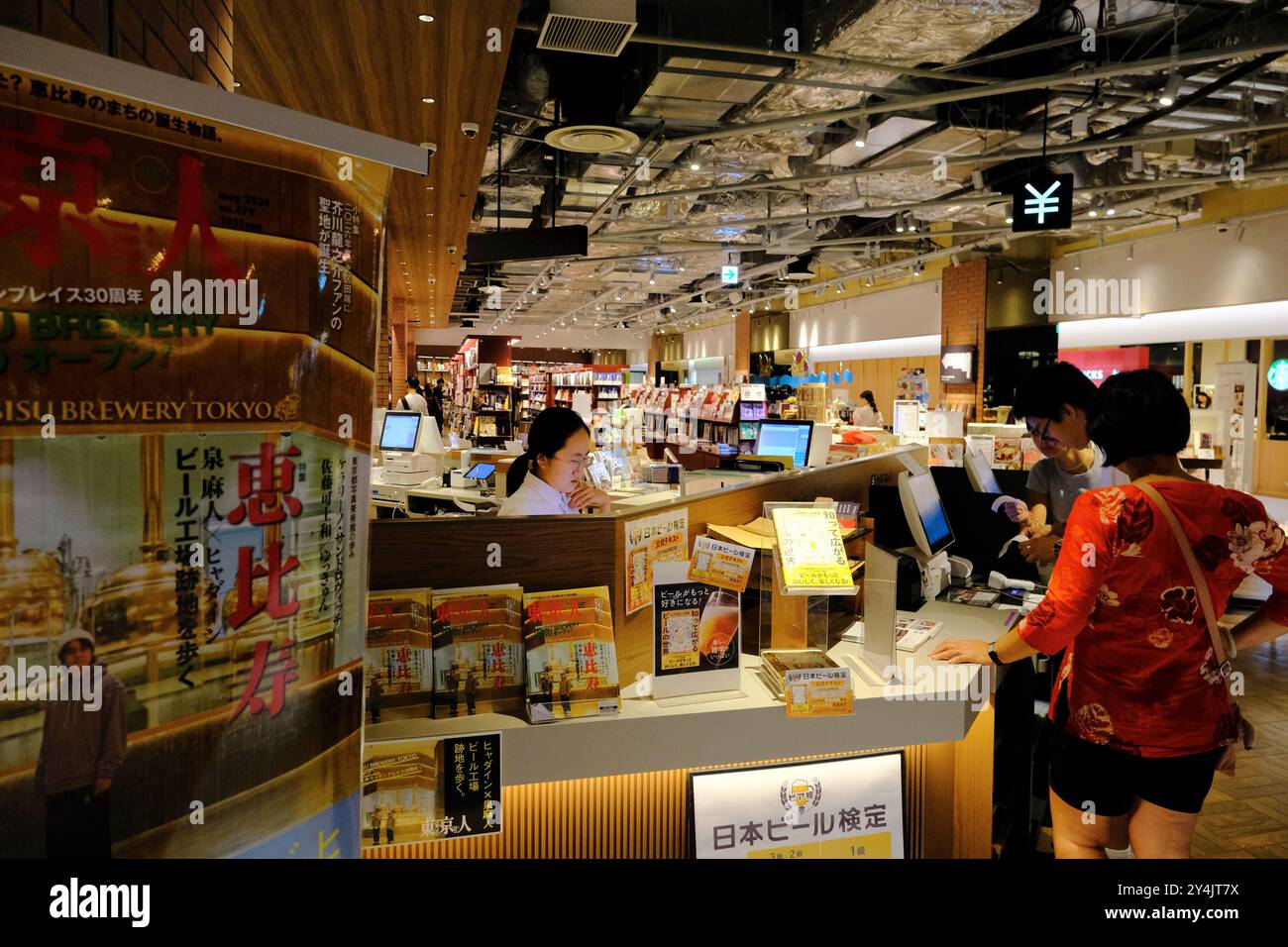 Customers buying books at self-checkout counter in Tsutaya Bookstore in Yebisu Garden Place Center Plaza, Ebisu,Shibuya Ward,Tokyo,Japan Stock Photo