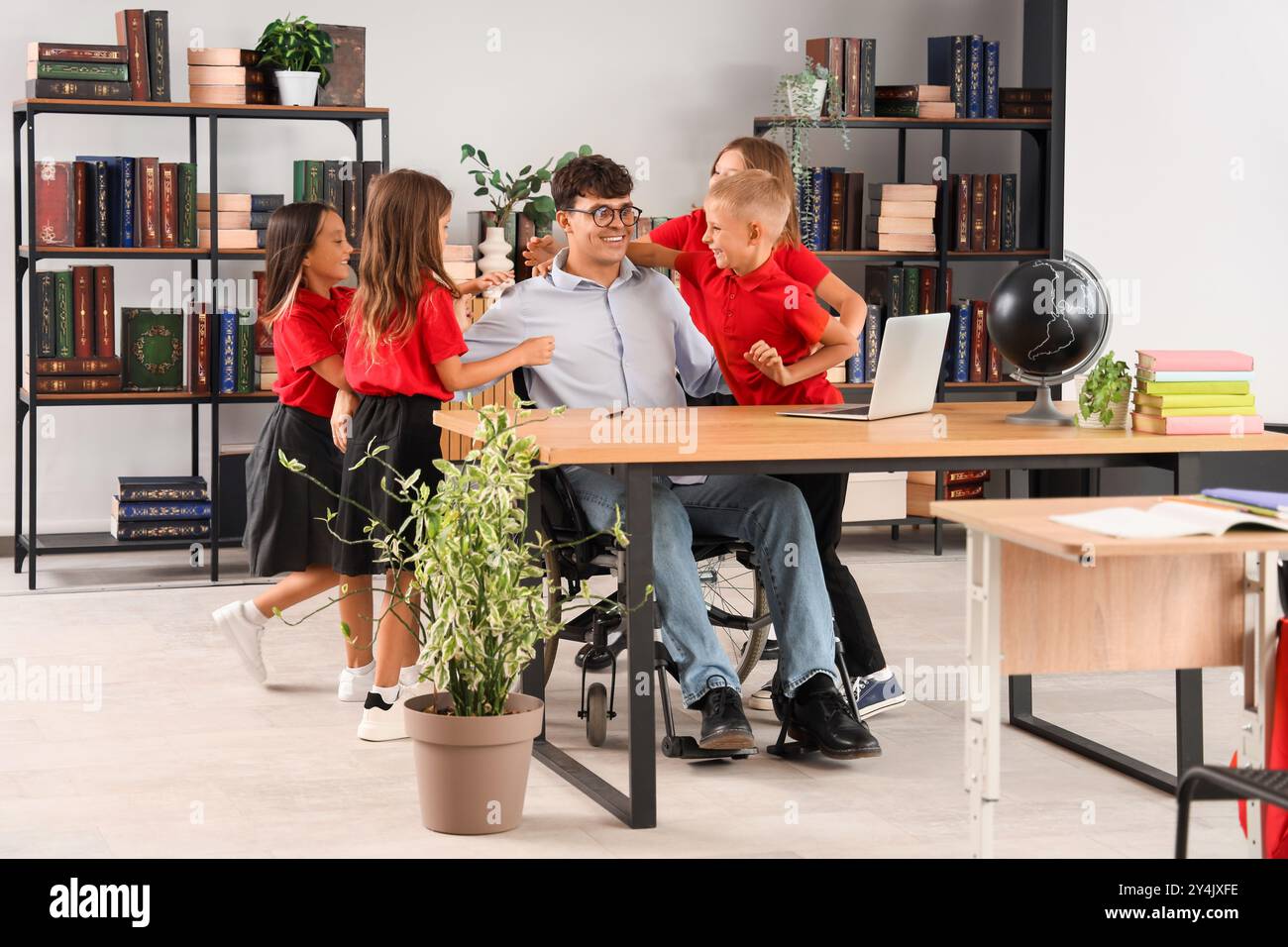 Male teacher in wheelchair with little pupils at school Stock Photo - Alamy
