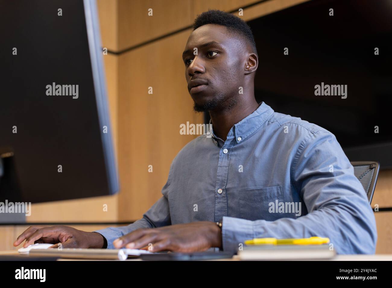 Working on desktop computer, man focusing on tasks in modern office Stock Photo
