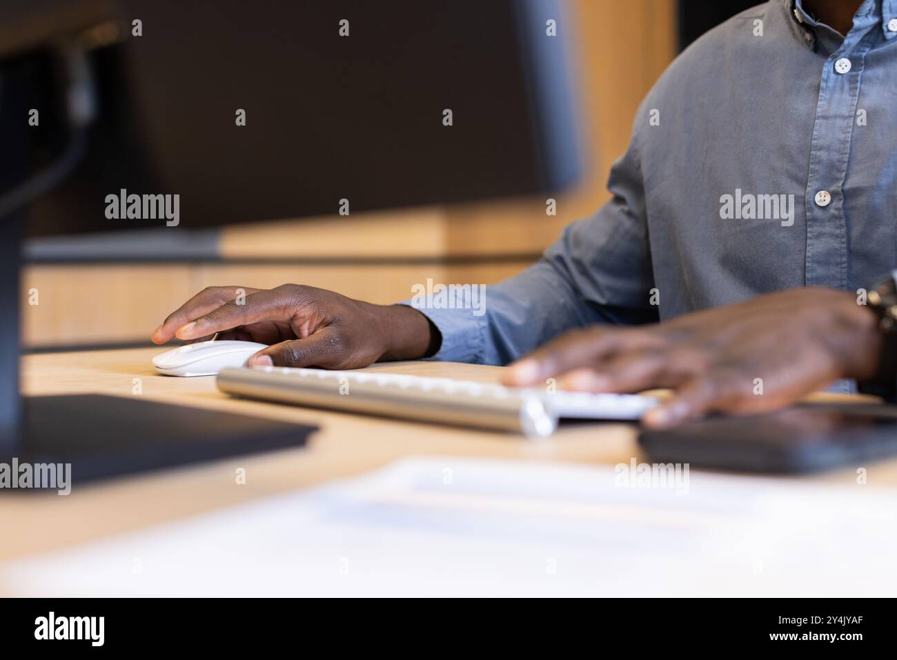 Using computer mouse and keyboard, person working in modern office environment Stock Photo