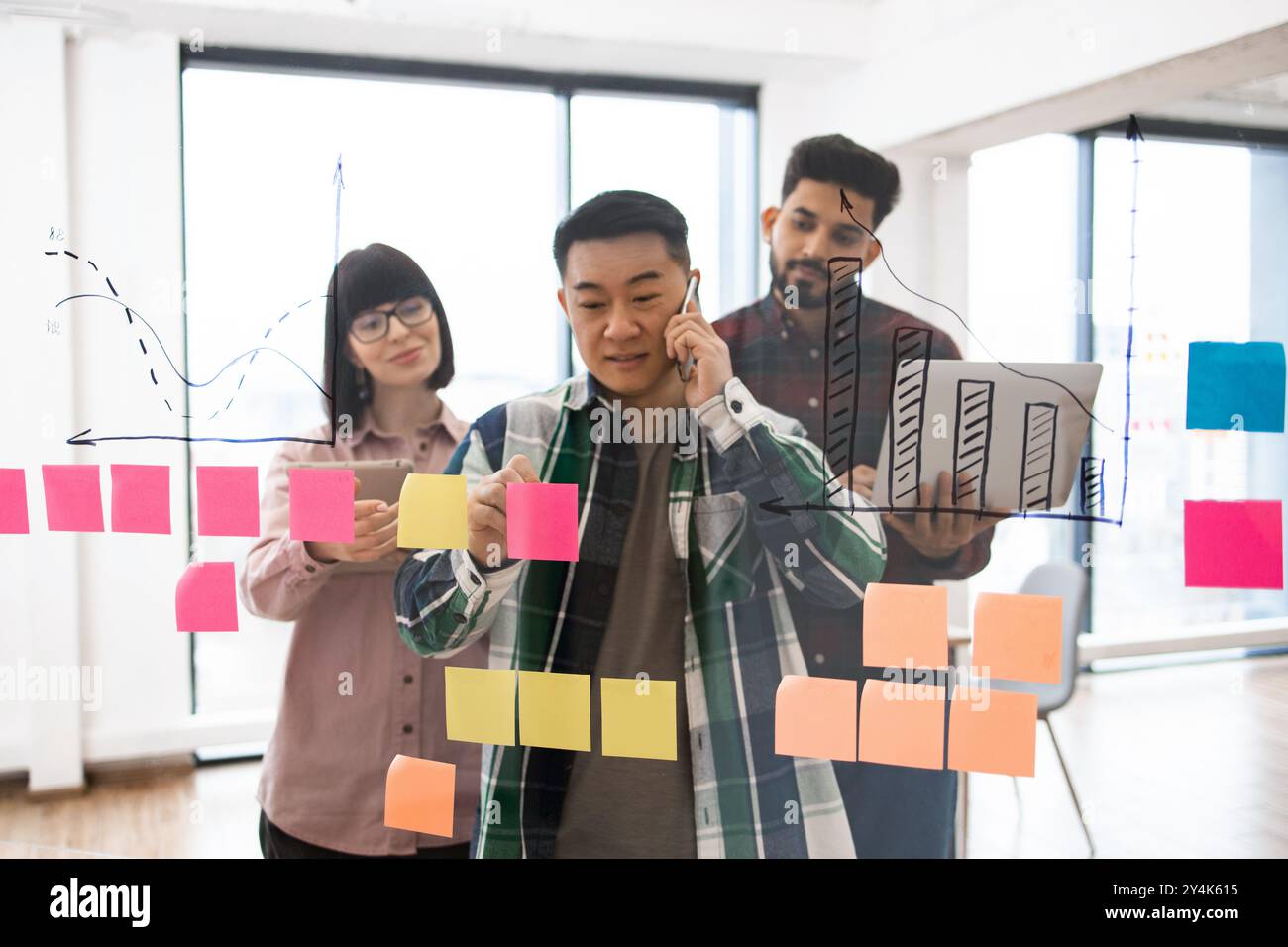 Team brainstorming ideas with sticky notes and charts Stock Photo - Alamy