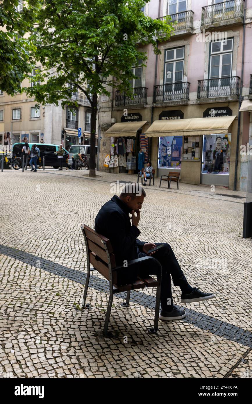 Europe, Portugal, Lisbon. A man smoking a cigarette in a Lisbon street  Stock Photo