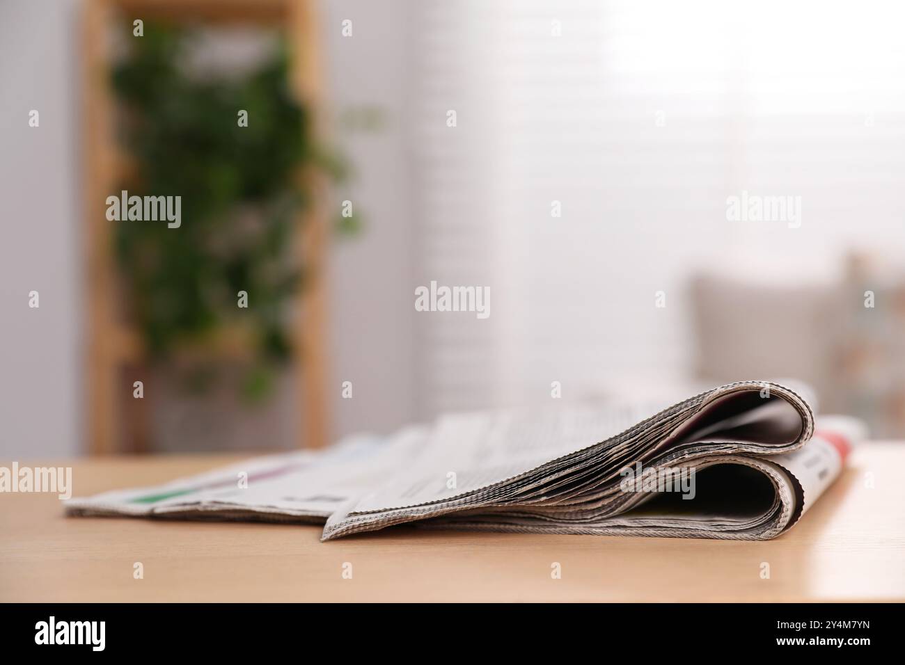 Stack of newspapers in different languages on table indoors Stock Photo