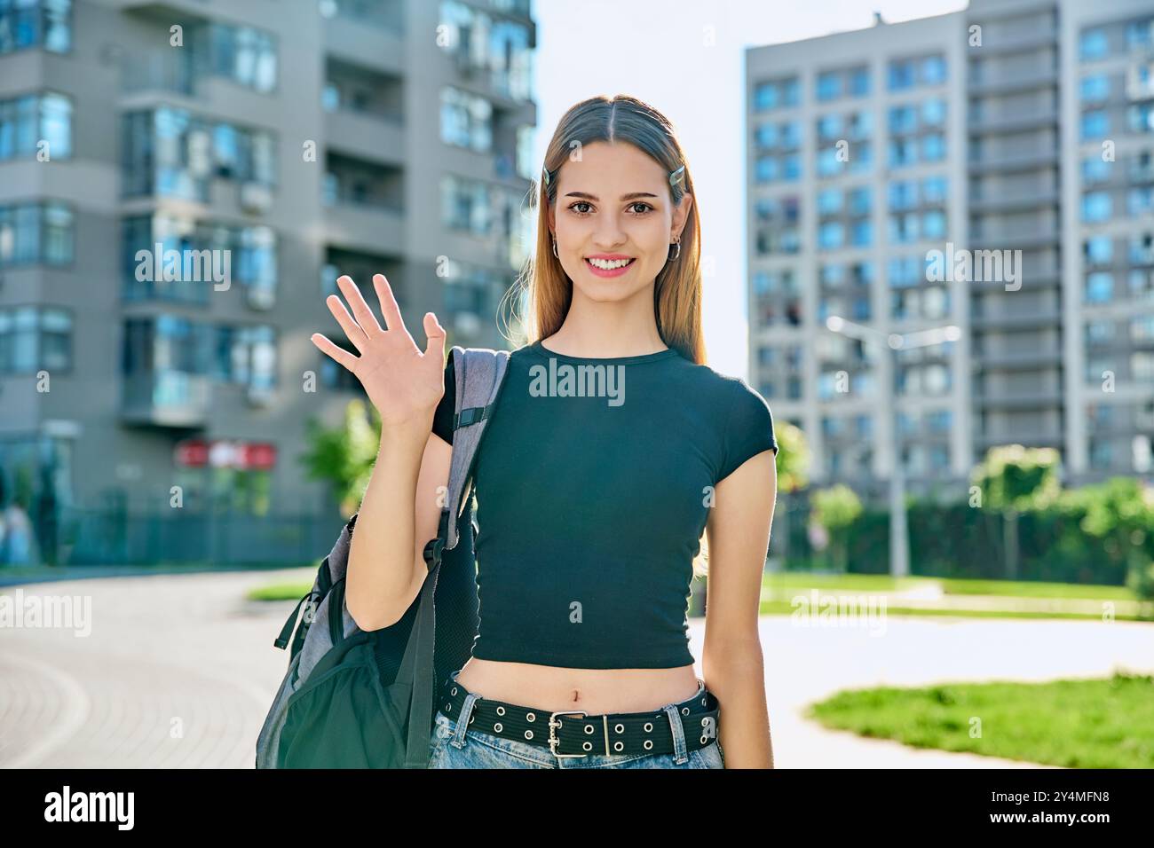 College student girl with backpack waving hand to camera, outdoor Stock ...