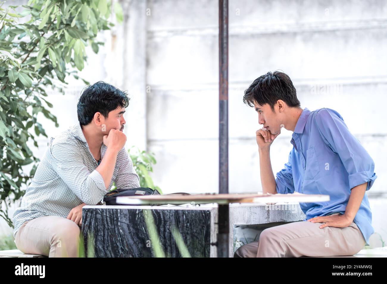 Two men arguing each other in the park. 2 men suspect each other. Stock Photo