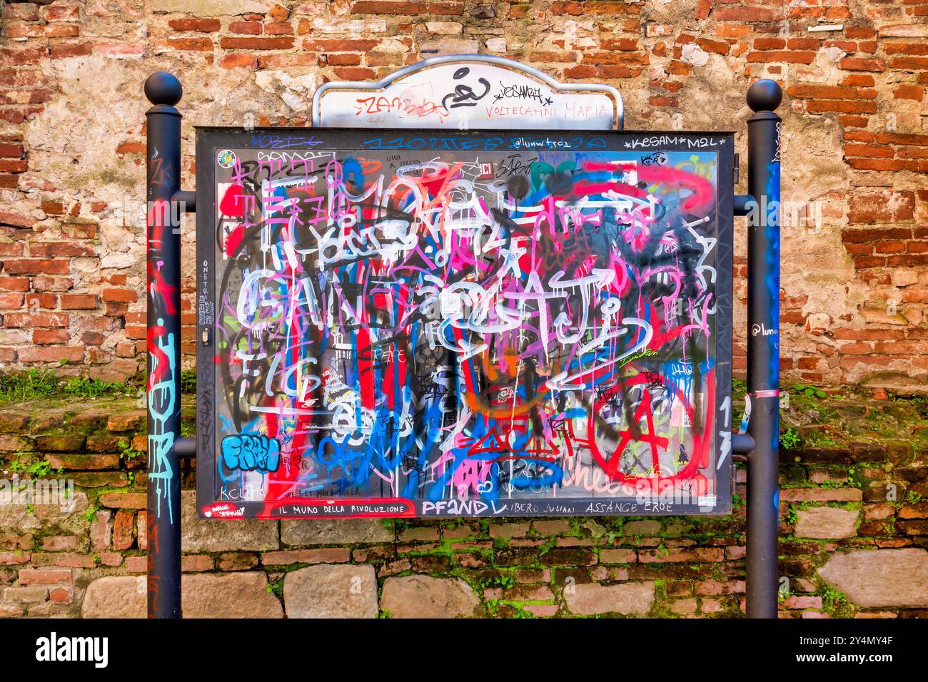 An advertising panel in Pisa, Italy, completely covered with colorful graffiti and tags Stock Photo