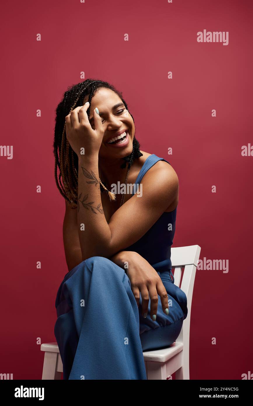 A young, trendy African American woman with braided hair smiles ...