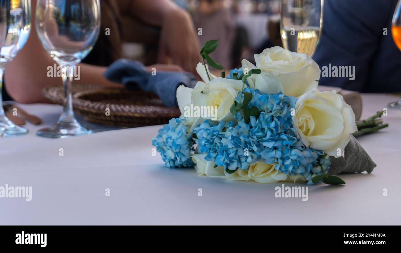 Close up of white roses centerpiece against blurred party background during daytime Stock Photo
