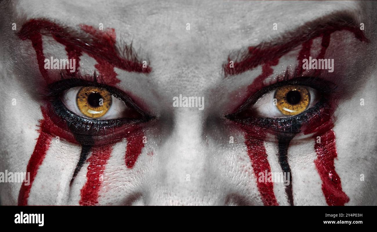 Blood-red tears dripping from gold serpent-like eyes create monstrous, terrifying effect. Vampire character. Stock Photo