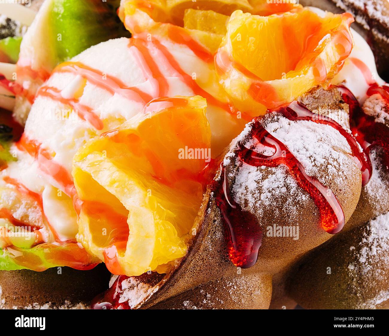 Egg waffle with ice cream and fruits with syrup Stock Photo