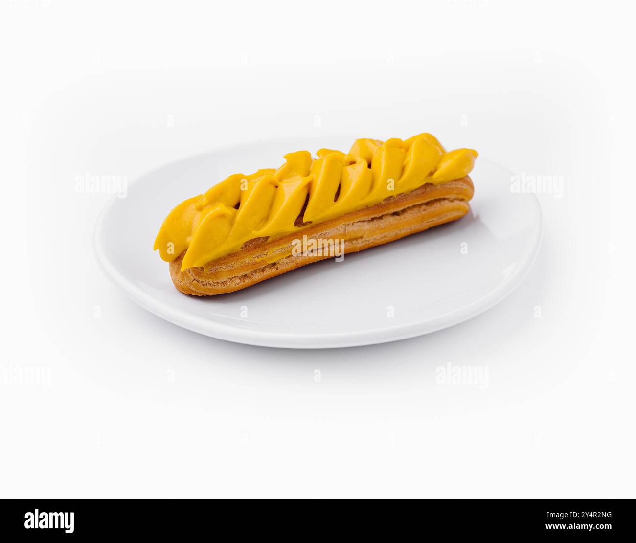 Eclair with Mango Cream on White Plate Stock Photo