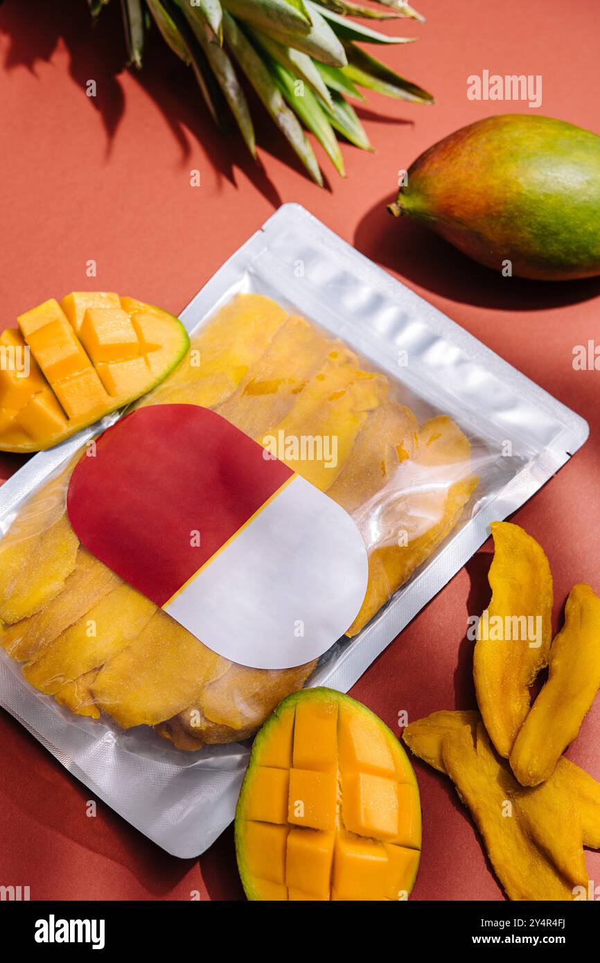 pack of dried mango slices and raw mango Stock Photo