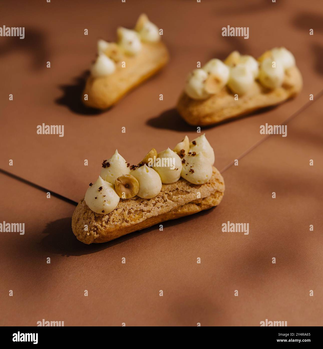 eclairs with whipped cream and hazelnuts Stock Photo