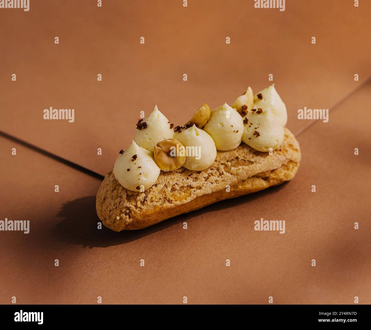 eclair with whipped cream and hazelnuts Stock Photo