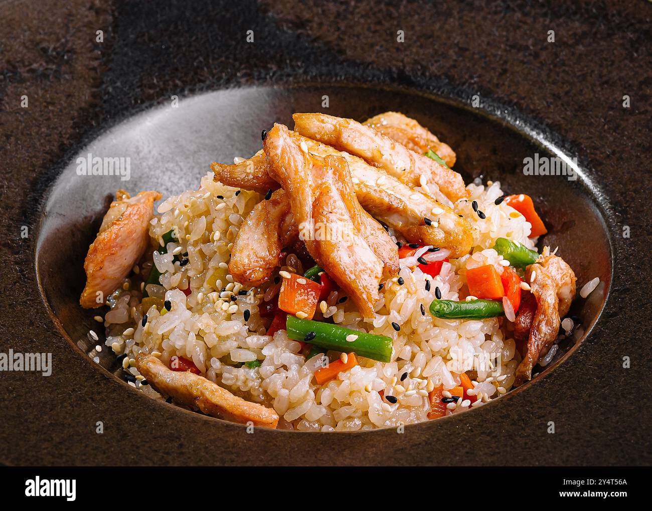 Servery Rice Savory chicken fried rice served on a stylish dark plate, perfect for a ...