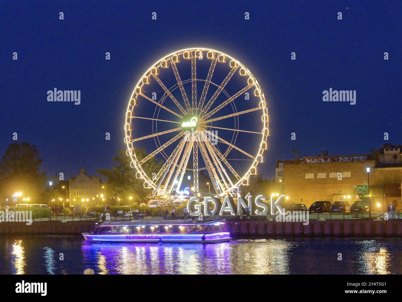 The Ferris wheel illuminated in the evening on the Motlawa, Motlawa, and the lettering Gdansk, Danzig, in the harbour district of Danzig. Gdansk, Pome Stock Photo