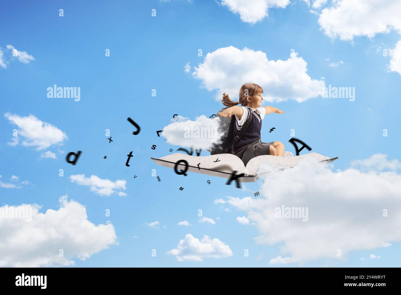 Happy little girl sitting on a book with letters and flying up in the ...