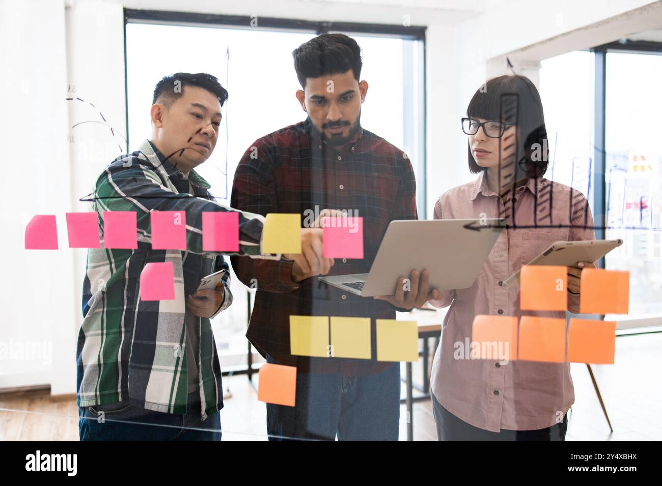 Creative team brainstorming with sticky notes and laptops Stock Photo ...