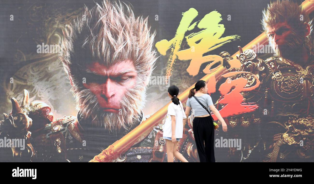 RENHUAI, CHINA - SEPTEMBER 15, 2024 - People walk past a poster ...