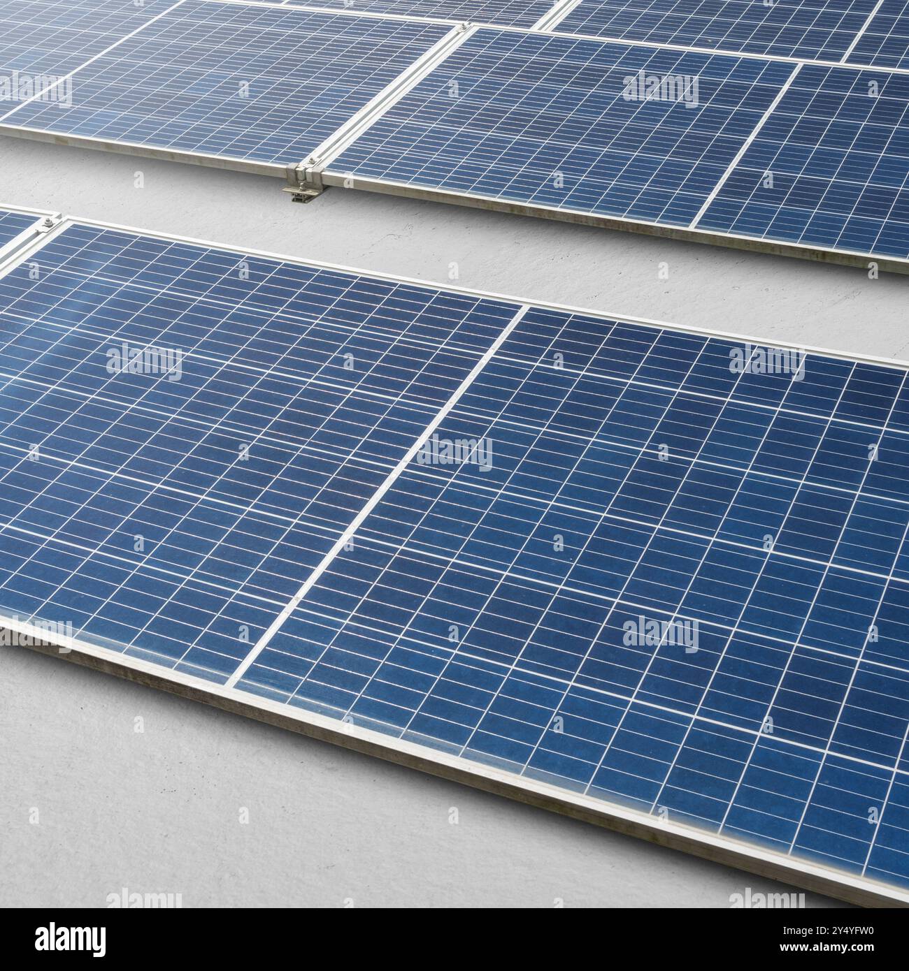 A solar panel or solar cell is shown in a close up. The panel is blue and has a grid pattern. Photovoltaic module. Alternative power source for saving Stock Photo