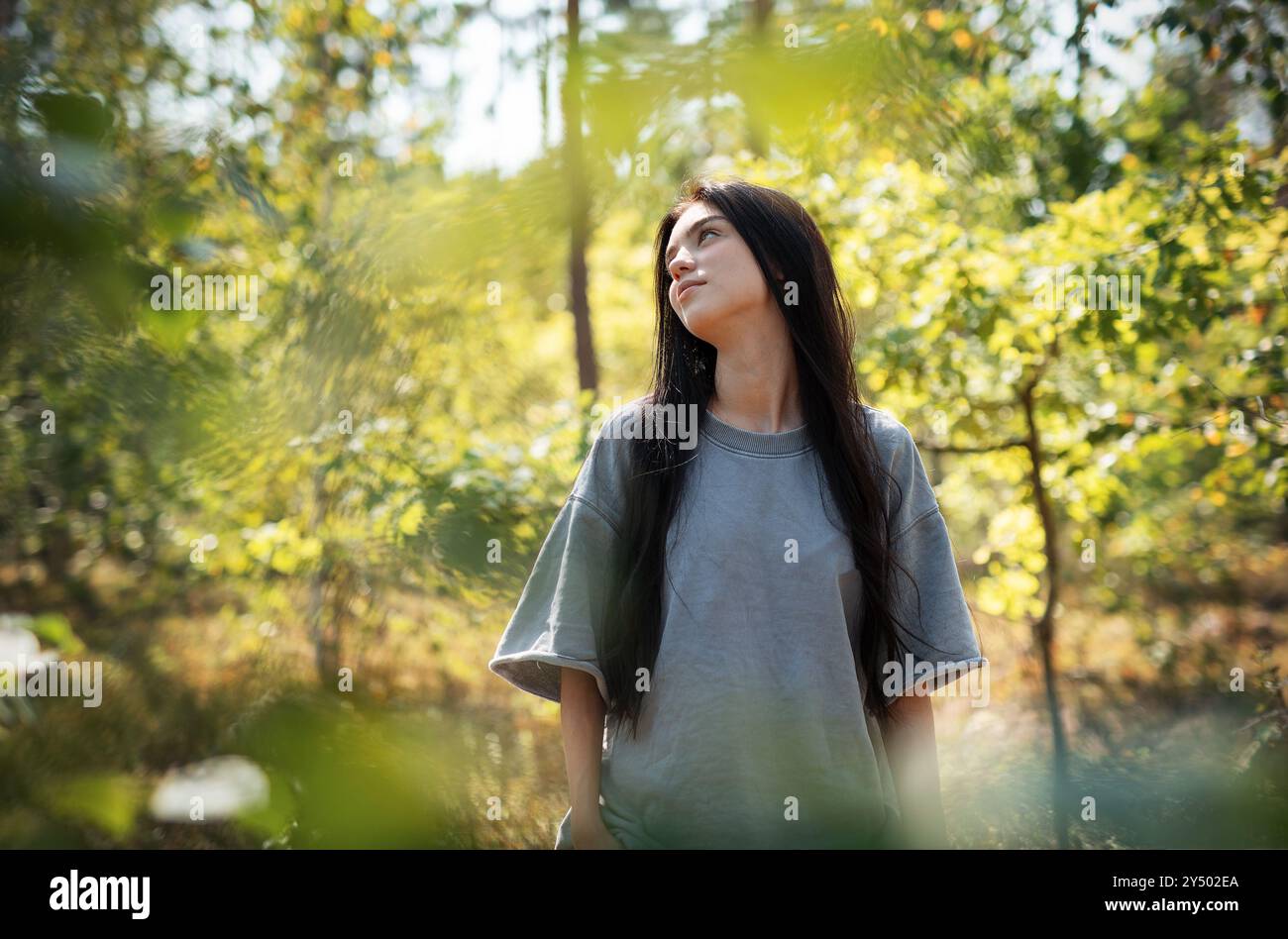 A young girl who breathes fresh air and relieves stress in the forest ...