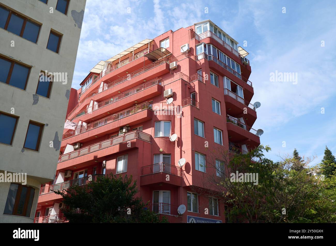 A striking pink building stands tall against the sky, featuring ...