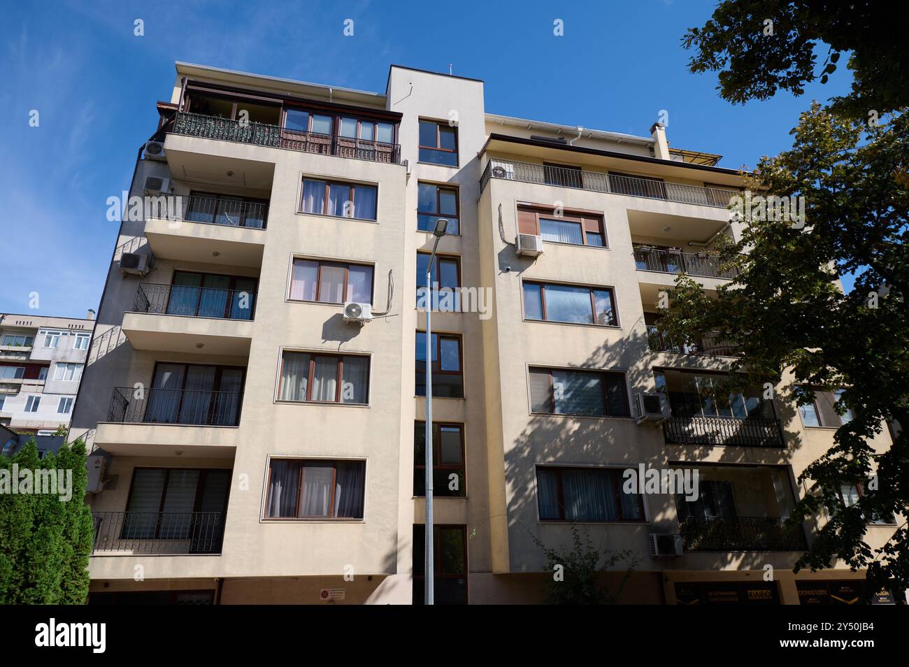 Modern apartment building with balconies against a clear blue sky in an ...