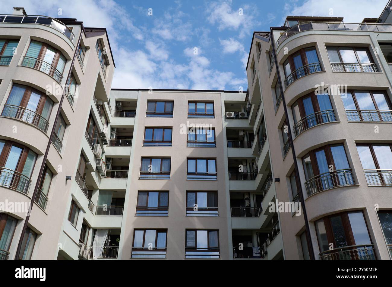 Modern apartment building with curved balconies under a bright sky in a ...