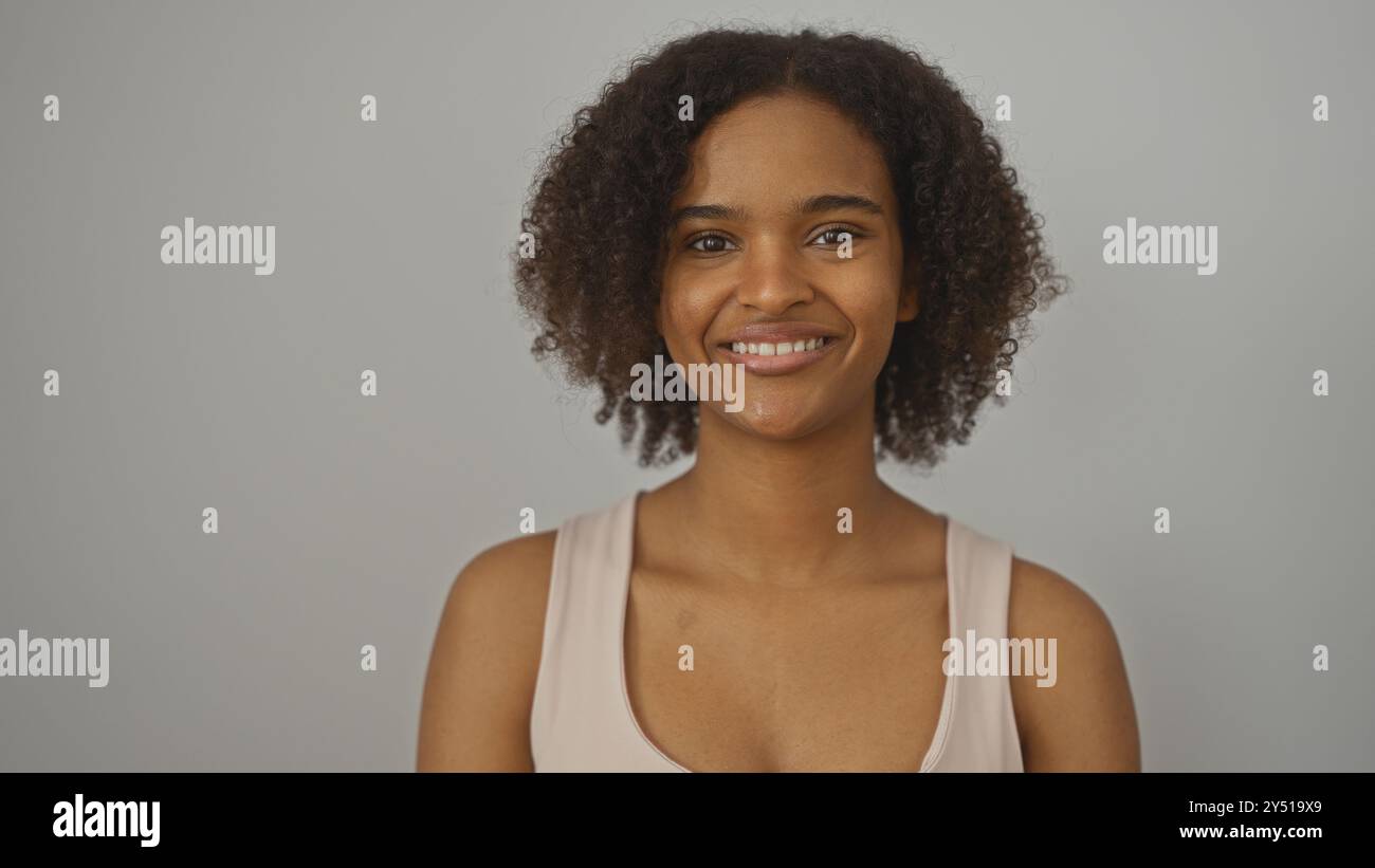 A beautiful young african american woman with curly hair smiles ...