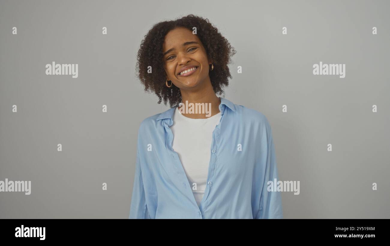A beautiful young african american woman with curly hair smiles warmly ...