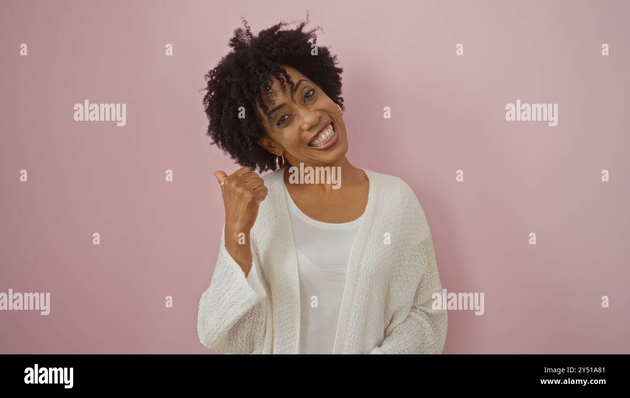 A beautiful young african american woman with curly hair poses in front ...