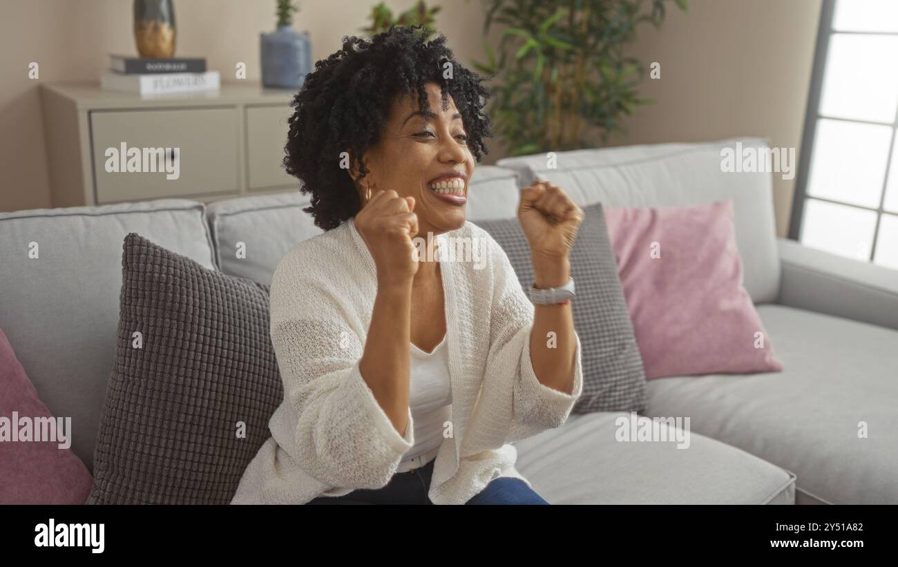 A beautiful young african american woman with curly hair sits on a ...