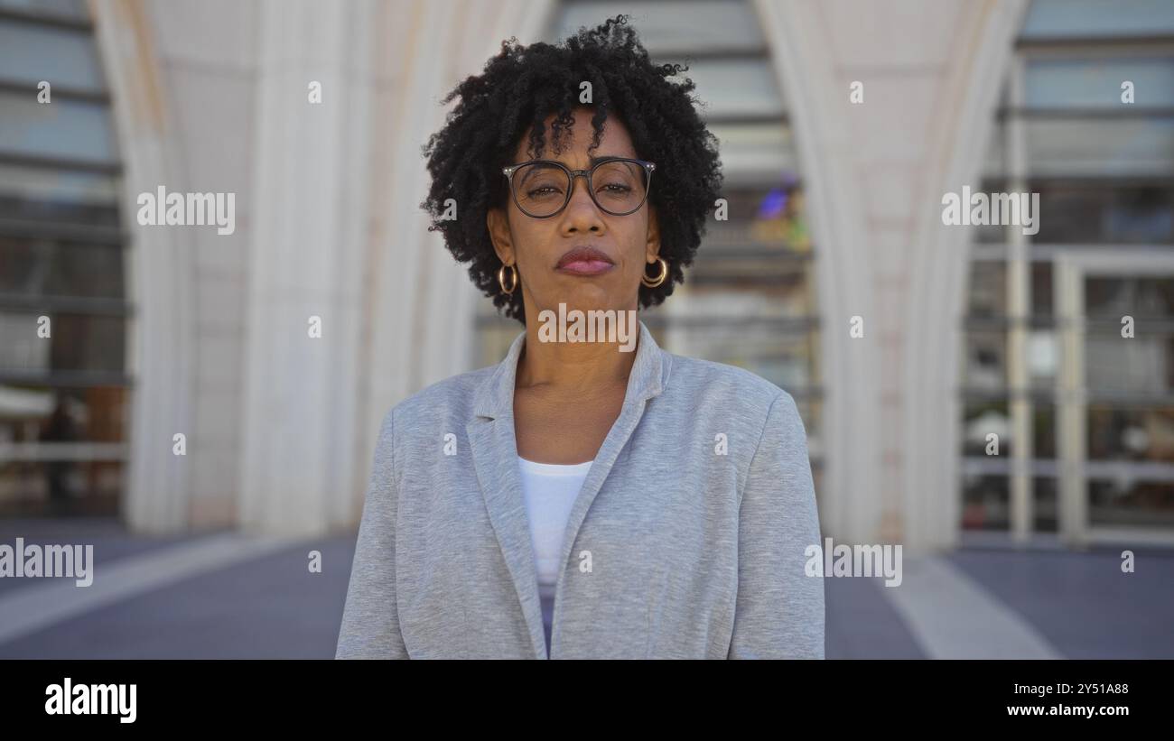 A beautiful young african american woman with curly hair stands ...