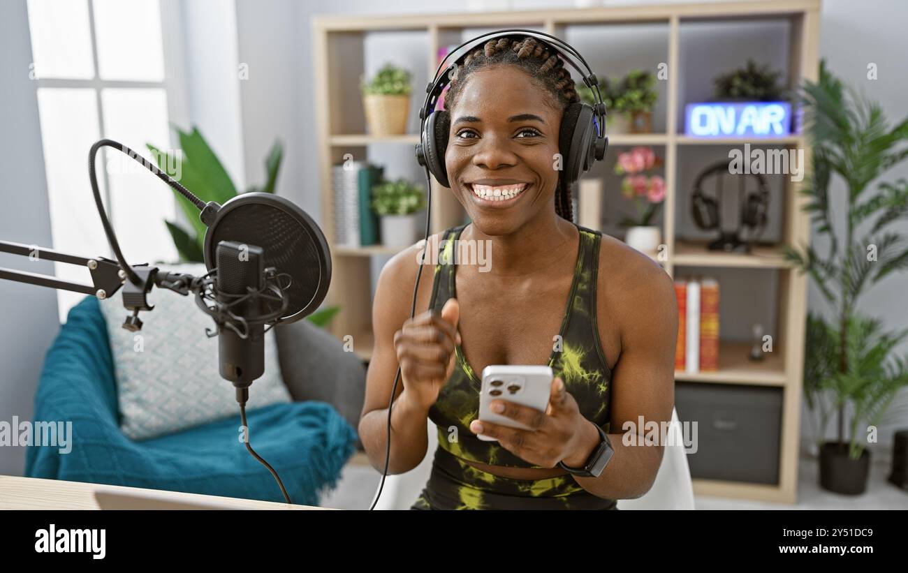 A smiling african american woman with braids wearing headphones in a ...