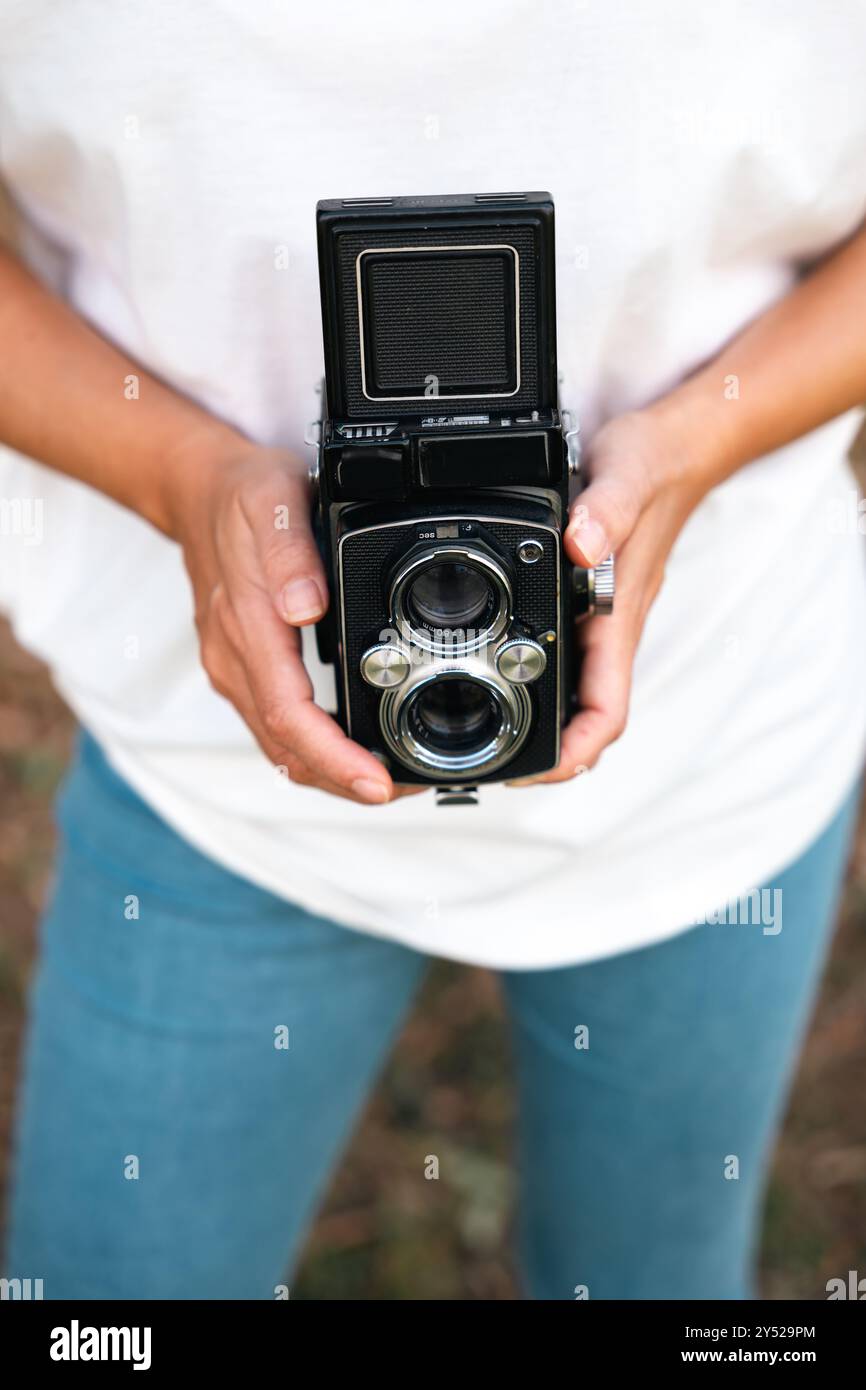 A woman's hands holding an analog medium format camera. Stock Photo