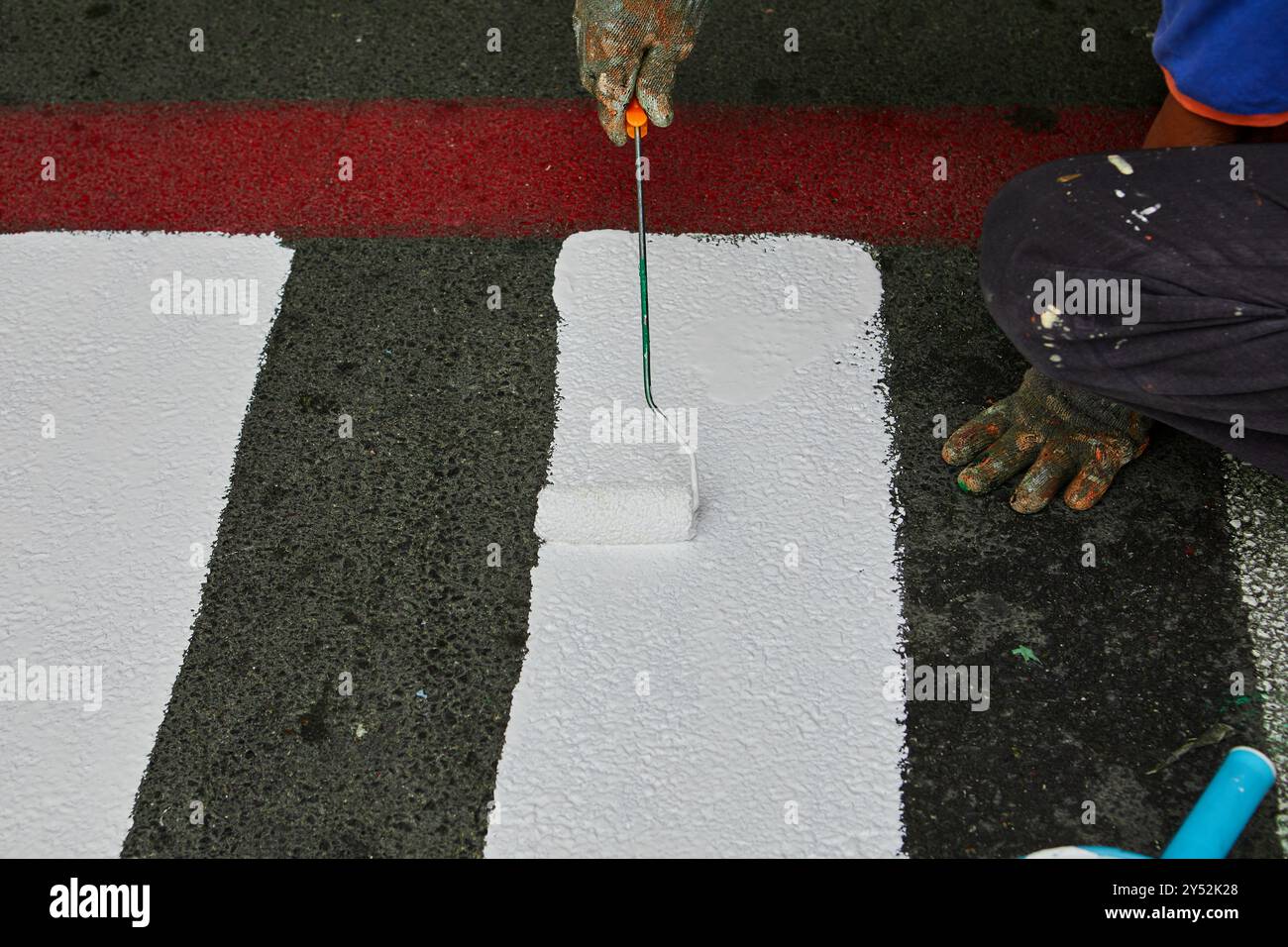 Worker using Paint roller and painting white color on footpath Stock ...