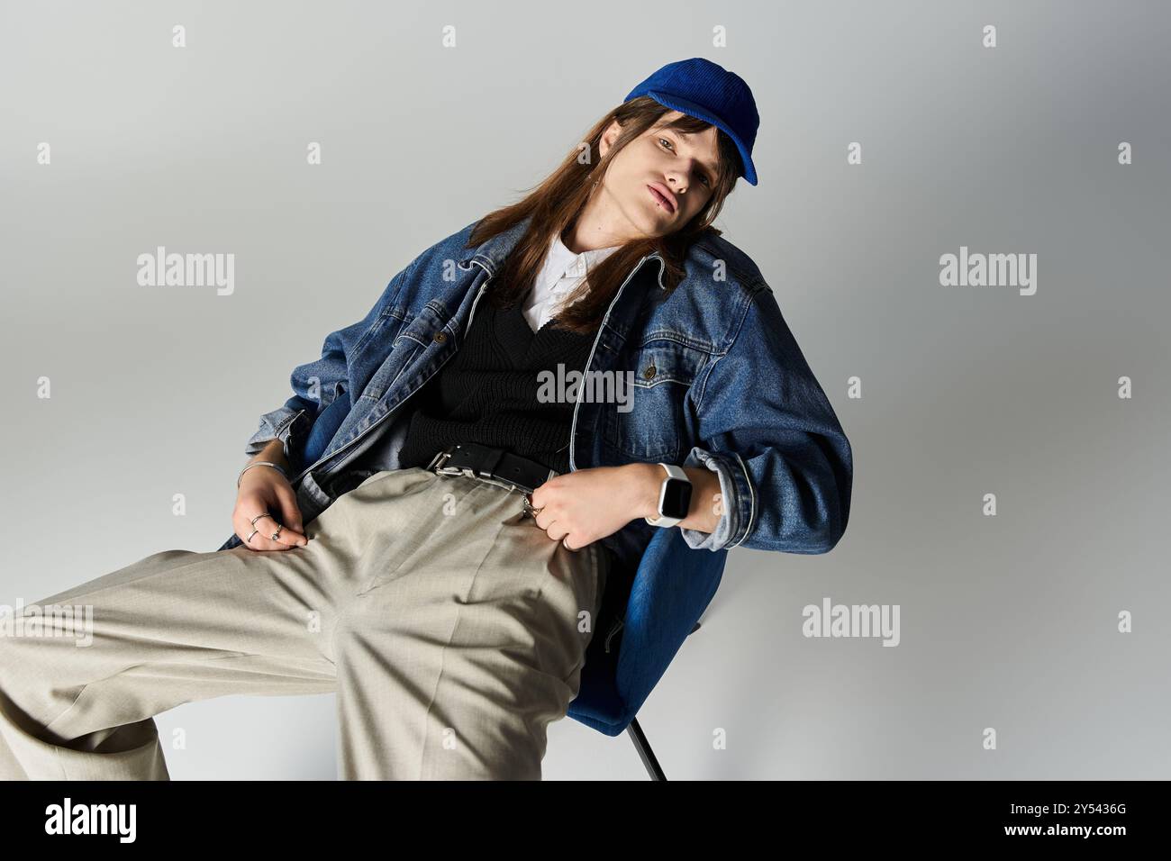 A fashion forward young man poses confidently in a modern studio ...