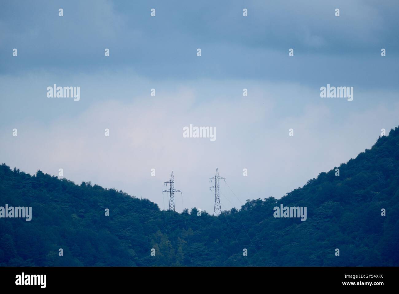 High-voltage power lines in the mountains on a cloudy day Stock Photo ...