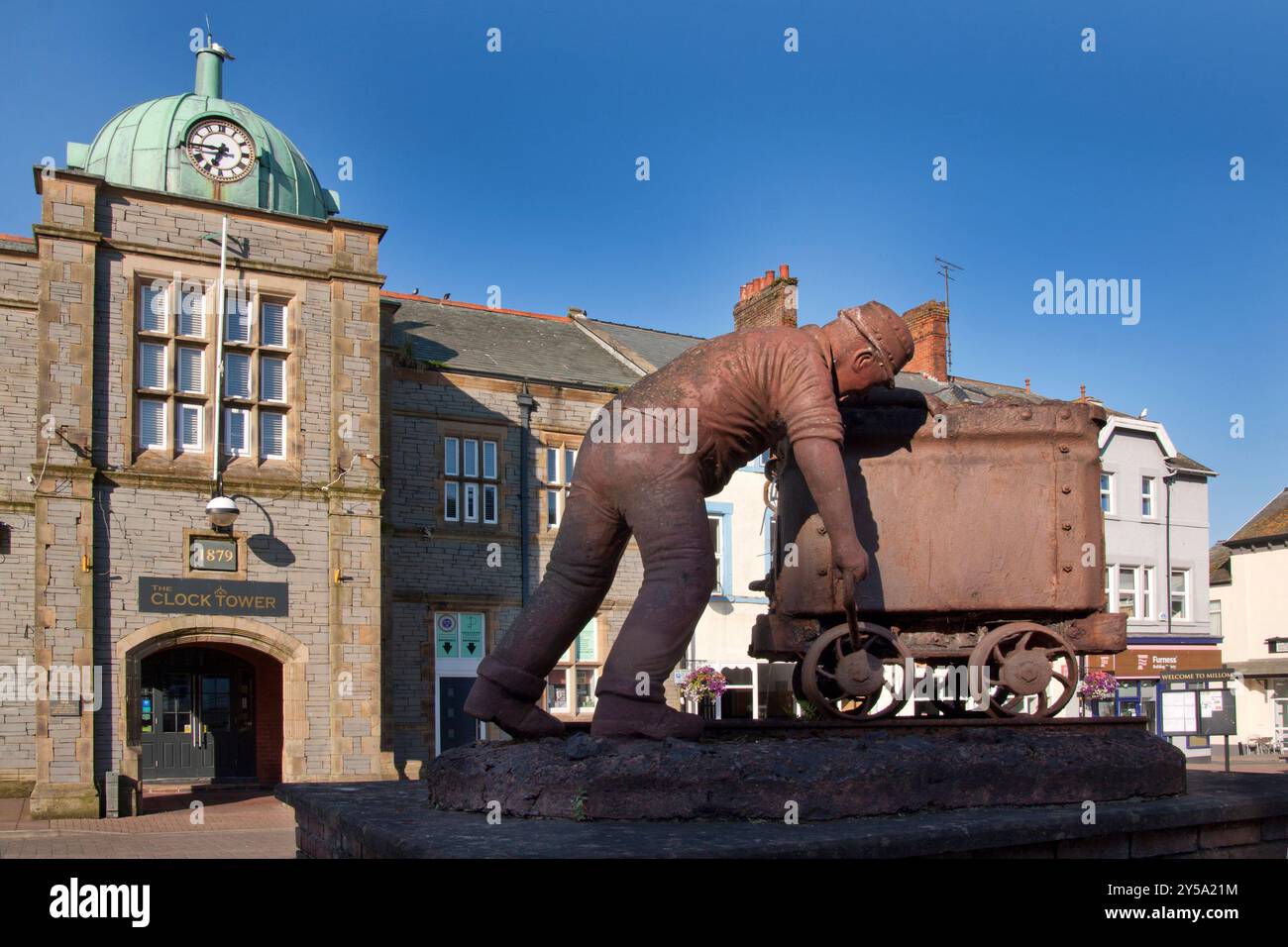 the Clock Tower and The Scutcher statue commemorating Millom's iron industry, Cumberland, Cumbria, England Stock Photo