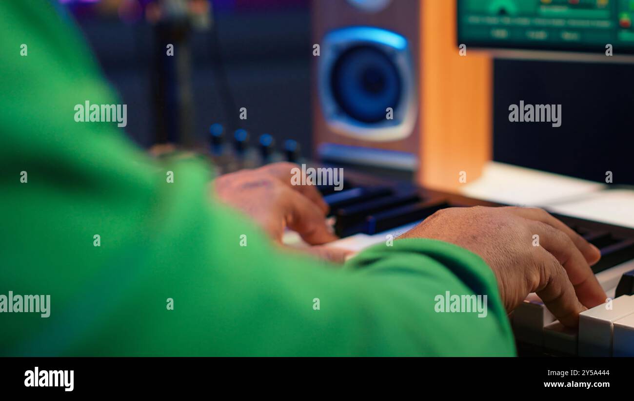 Sound engineer playing piano and mixing tunes on digital software ...