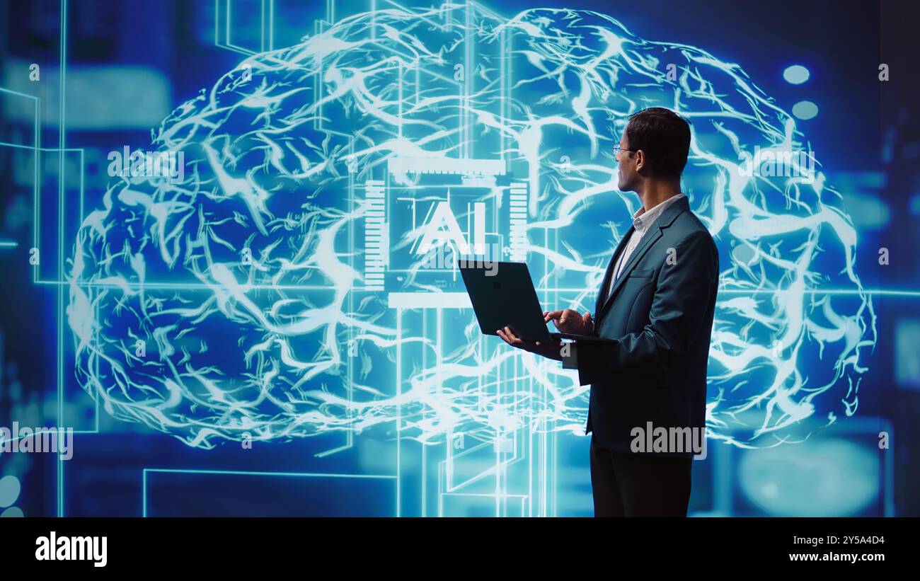 IT expert solving tasks on laptop device, running artificial intelligence programming scripts. Indian man using notebook to write lines of code for AI applications development, camera B Stock Photo