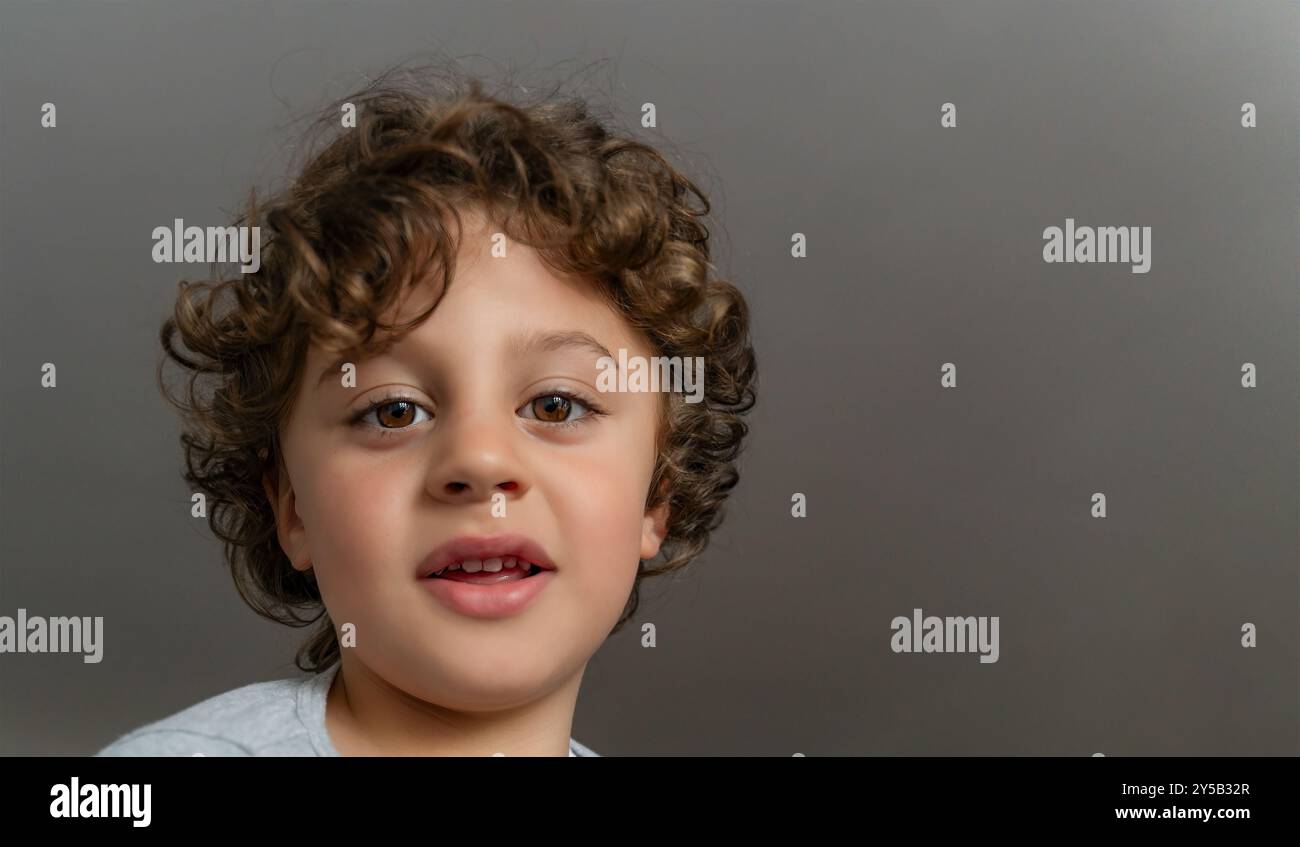 Portrait of a cute happy little and adorable boy, isolated on gray background -  Childhood concept Stock Photo