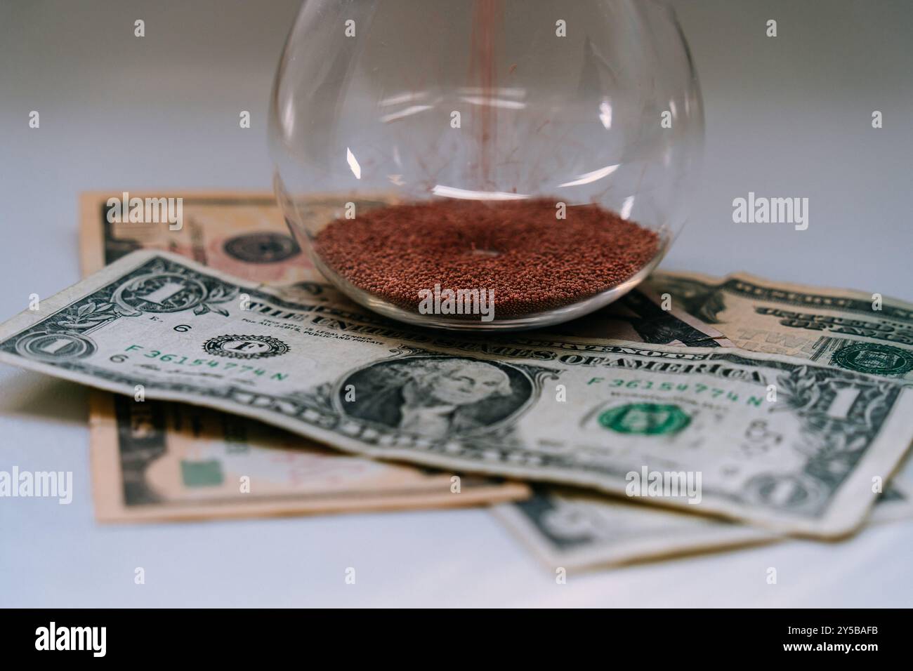 Hourglass with dollar bills representing savings compound interest or
