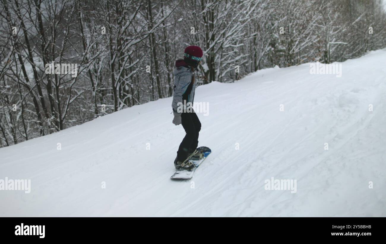Woman riding snowboard on snow slope ski resort. Active sport, recreation, outdoor lifestyle travel on winter holiday vacation in Bukovel, Carpathian mountains Stock Photo