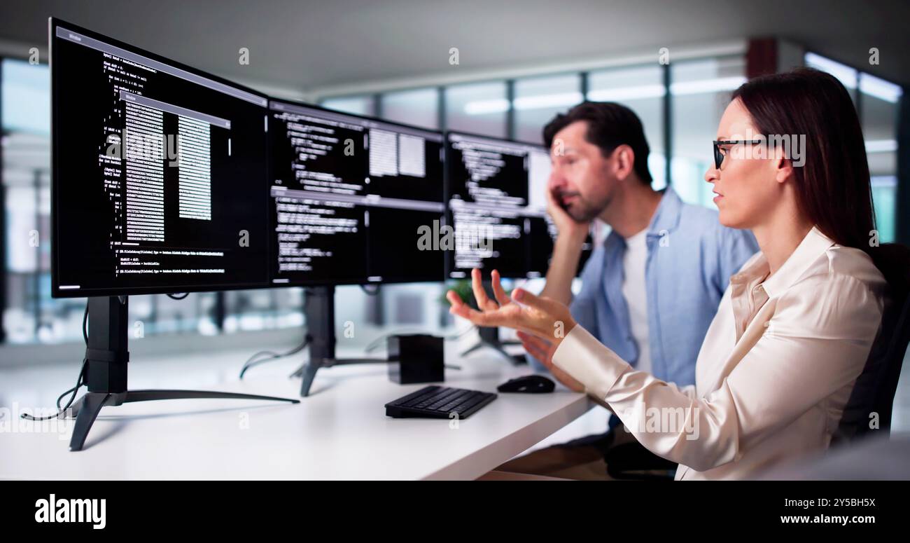 Unhappy Sad Developer Programmers In Stress Coding Software On Computer Stock Photo