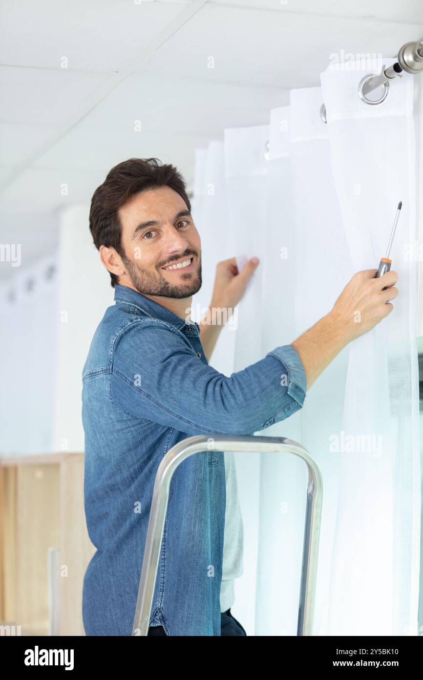 man installing window blinds at home Stock Photo