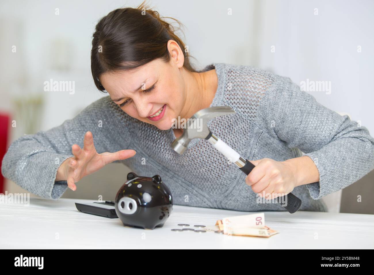 sad girl with piggy bank and hammer Stock Photo - Alamy