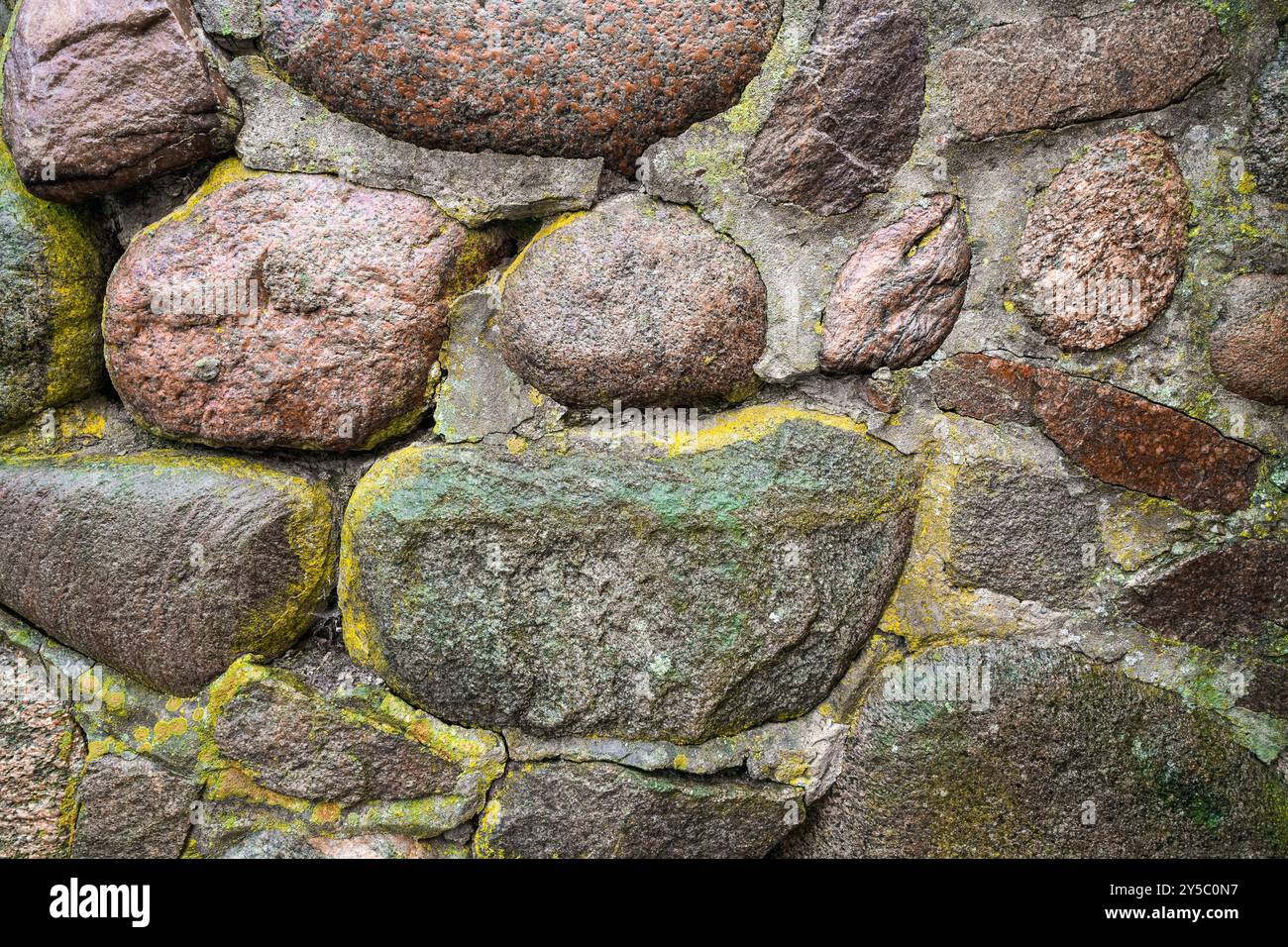 Old stone wall with moss and lichen. Rustic natural background. Stock Photo