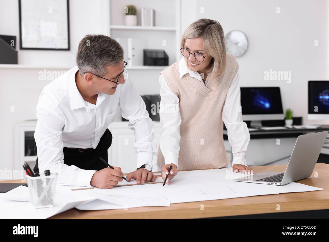 Architects making engineering drawing at wooden table in office Stock Photo
